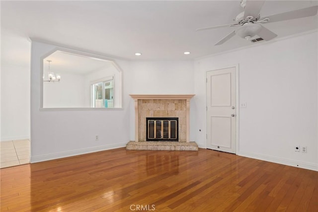 unfurnished living room featuring crown molding, hardwood / wood-style floors, and ceiling fan with notable chandelier