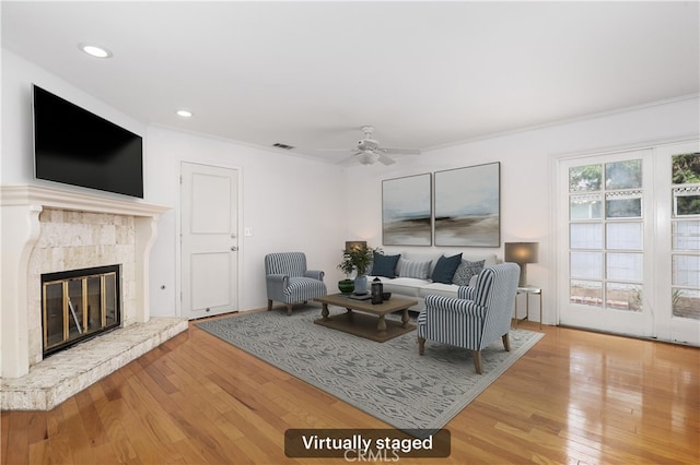 living room with ceiling fan, wood-type flooring, and ornamental molding