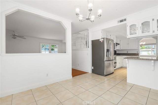 kitchen featuring white cabinets, stainless steel fridge with ice dispenser, ceiling fan with notable chandelier, and plenty of natural light