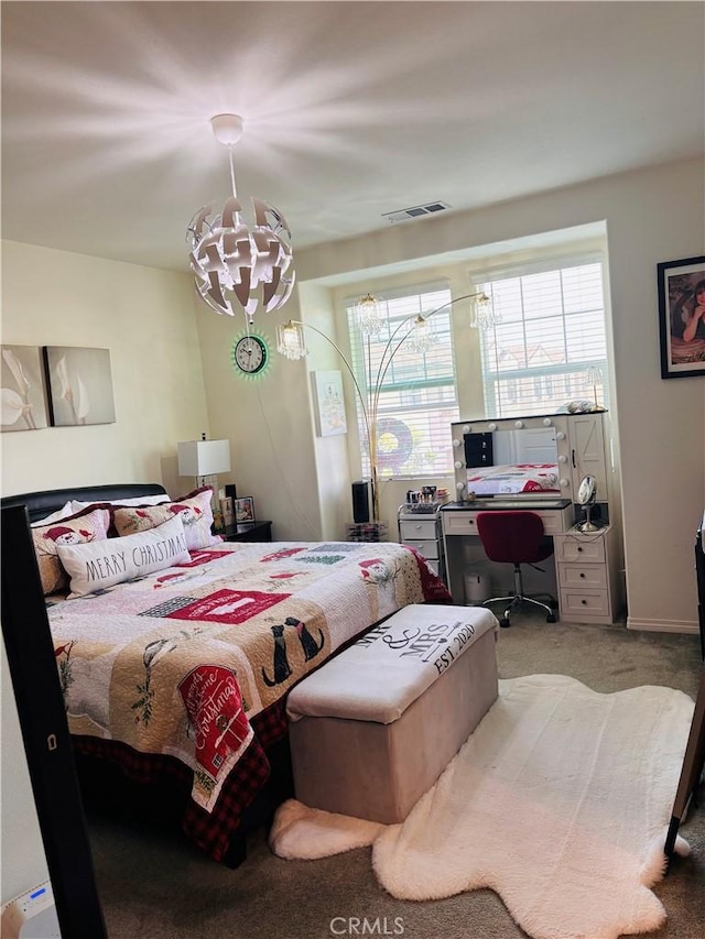 bedroom featuring carpet and an inviting chandelier