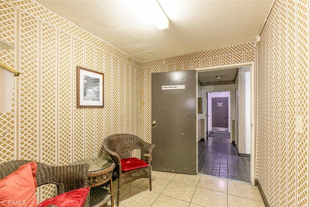 hall with light tile patterned floors and a textured ceiling