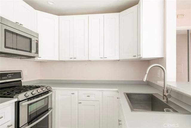 kitchen featuring white cabinets, stainless steel appliances, and sink