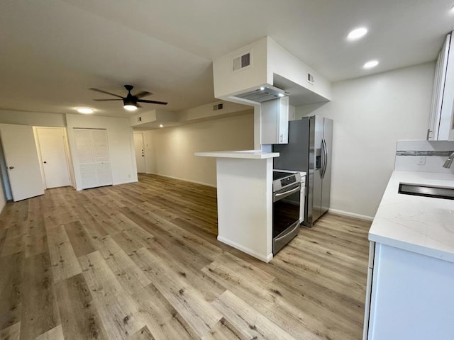 kitchen featuring ceiling fan, sink, stainless steel appliances, light hardwood / wood-style floors, and white cabinets