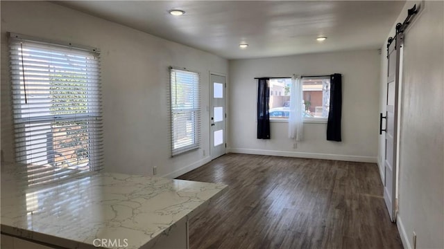 foyer with dark hardwood / wood-style flooring and a barn door