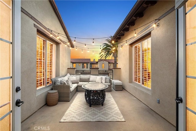 balcony at dusk with a patio area and outdoor lounge area