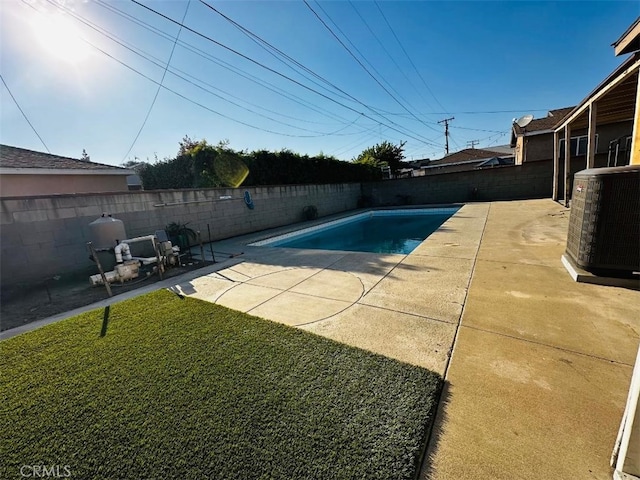 view of swimming pool featuring a patio area, a yard, and central AC unit