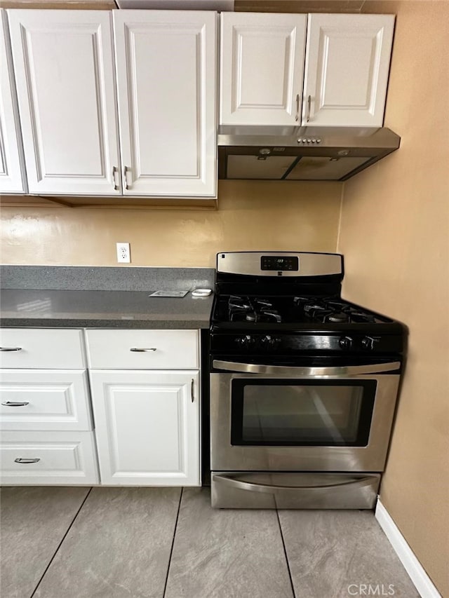 kitchen with stainless steel gas stove, white cabinets, and light tile patterned flooring