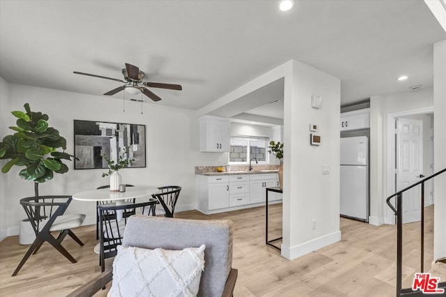 dining area featuring ceiling fan, light hardwood / wood-style floors, and sink