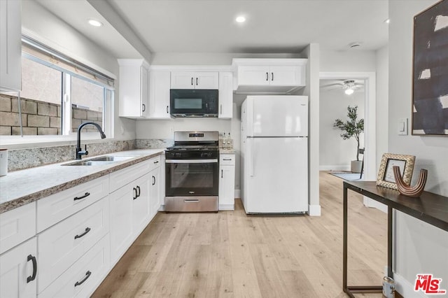 kitchen with sink, white refrigerator, light hardwood / wood-style flooring, white cabinets, and stainless steel range with gas cooktop