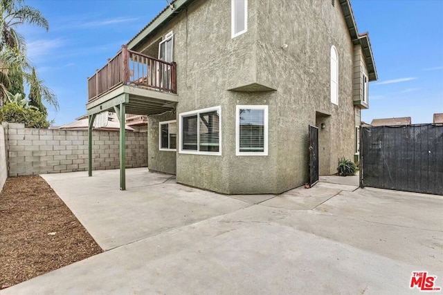 rear view of house featuring a balcony and a patio area