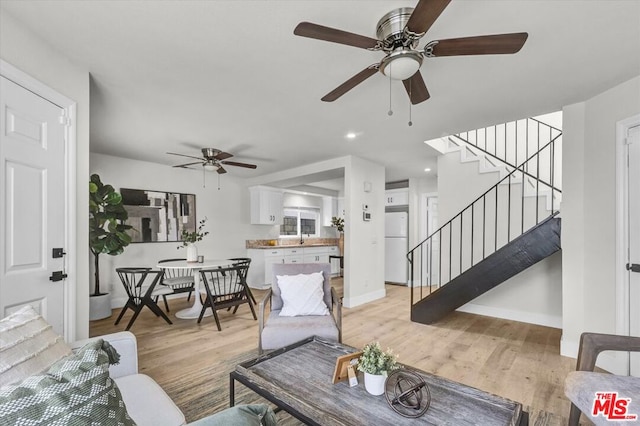 living room with ceiling fan and light hardwood / wood-style flooring