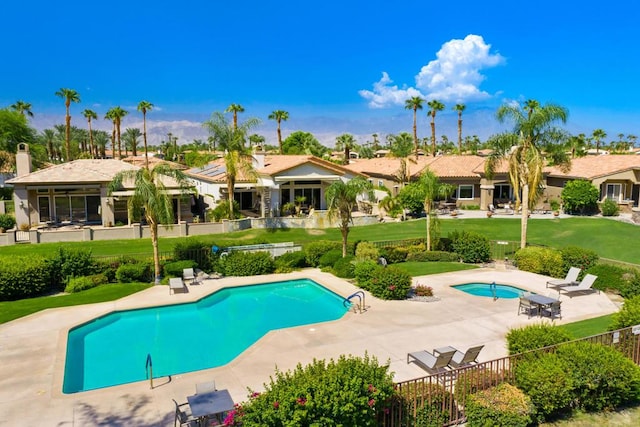 view of pool with a patio area and a lawn