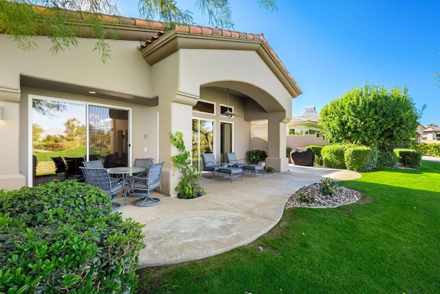 rear view of property with a yard and a patio