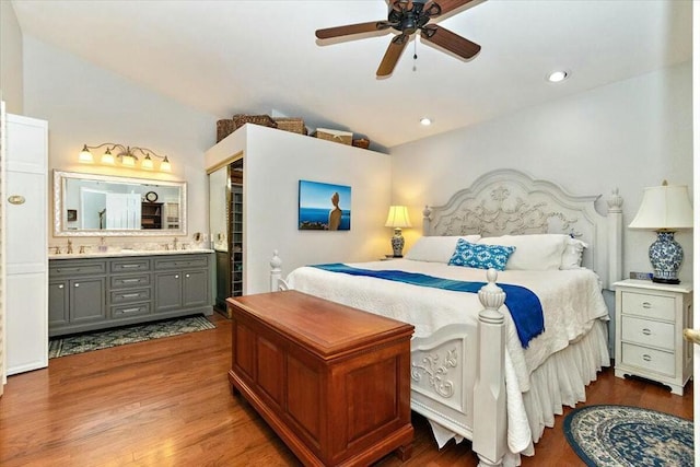 bedroom featuring ensuite bathroom, sink, vaulted ceiling, ceiling fan, and dark hardwood / wood-style flooring