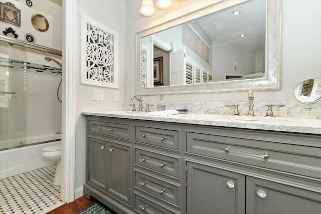 full bathroom featuring combined bath / shower with glass door, vanity, tile patterned flooring, and toilet