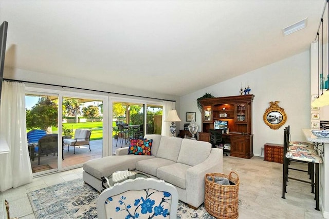 tiled living room featuring lofted ceiling and a healthy amount of sunlight