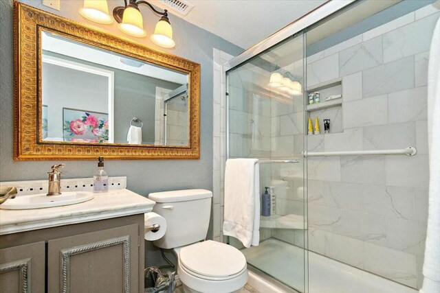 bathroom with vanity, toilet, and walk in shower