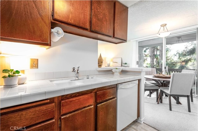 8635 Falmouth Ave Unit 301, Playa Del Rey, CA 90293 - kitchen featuring white dishwasher, brown cabinetry, a sink, and light carpet
