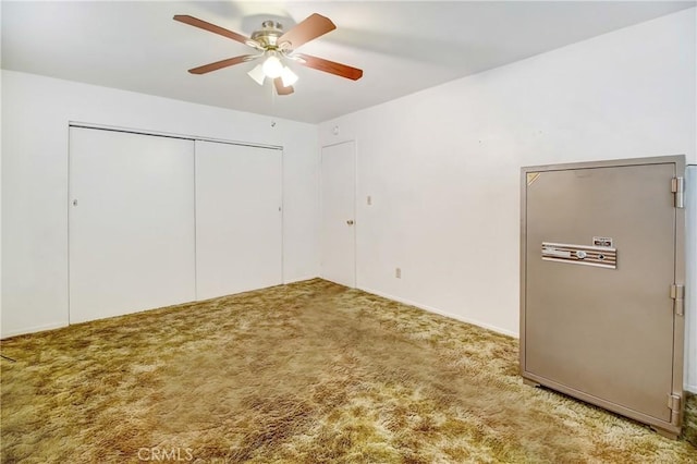 unfurnished bedroom featuring ceiling fan, a closet, and carpet floors