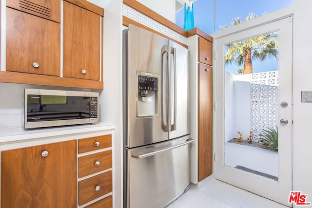 kitchen with light tile patterned floors and stainless steel appliances