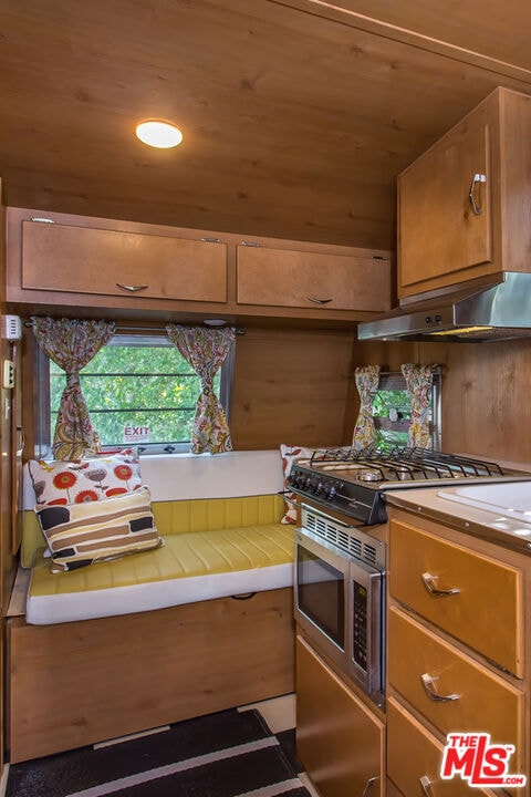 kitchen featuring tile countertops, wooden ceiling, and stainless steel range with gas stovetop