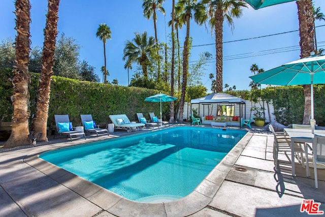 view of swimming pool with a gazebo, an outdoor living space, and a patio area