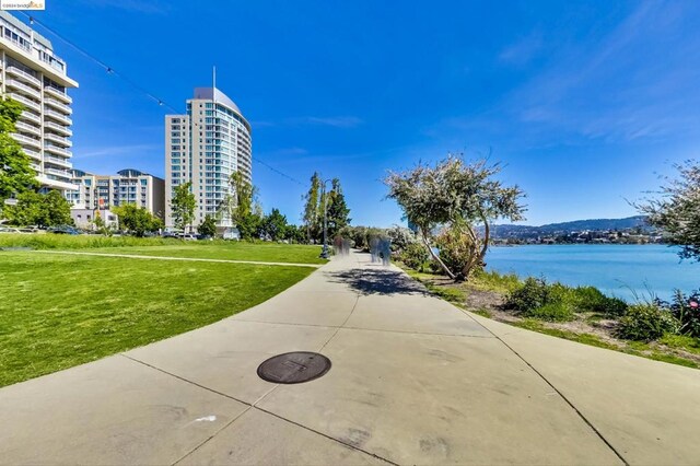 view of property's community with a lawn and a water view