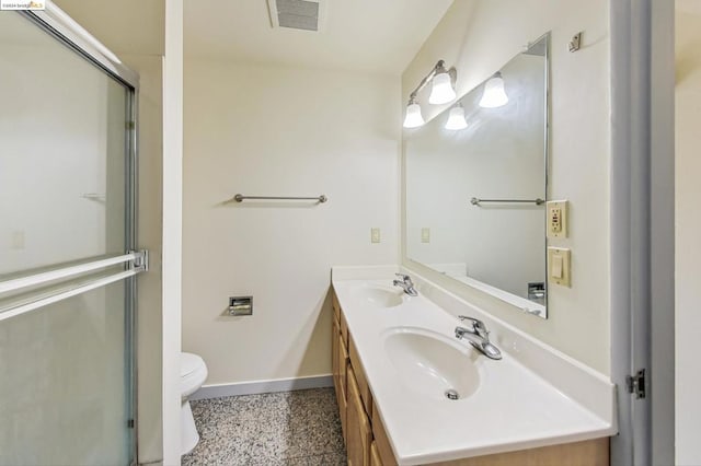 bathroom with vanity, toilet, and a shower with door