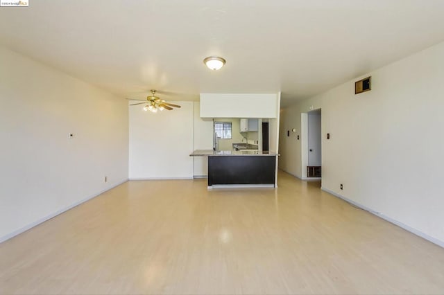 unfurnished living room featuring ceiling fan and light hardwood / wood-style flooring