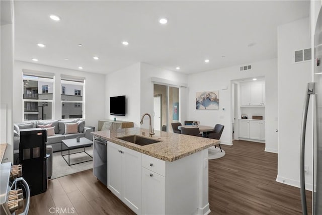 kitchen with white cabinets, light stone counters, sink, a center island with sink, and dishwasher