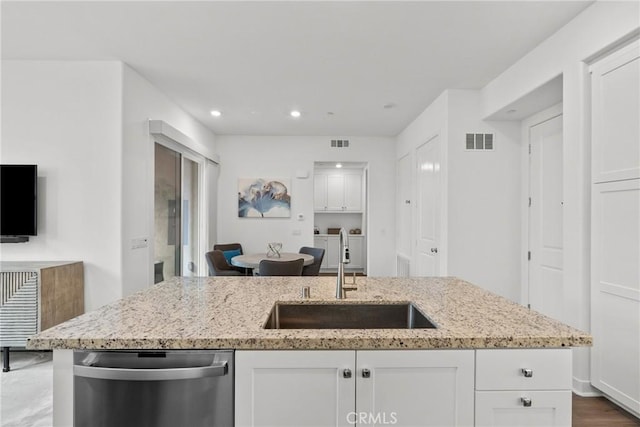 kitchen with white cabinets, dishwasher, light stone counters, and sink