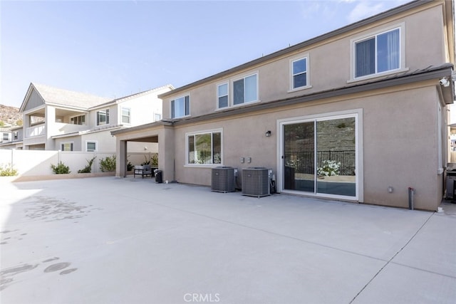 back of property with central AC unit and a patio area