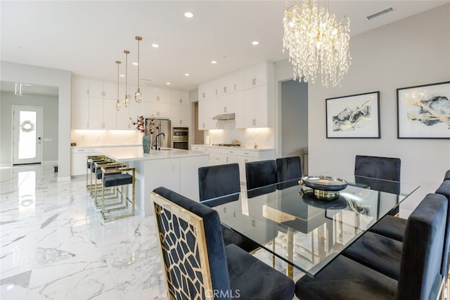 dining space with a notable chandelier and sink