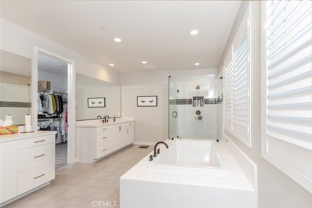 bathroom with vanity, tile patterned flooring, and plus walk in shower