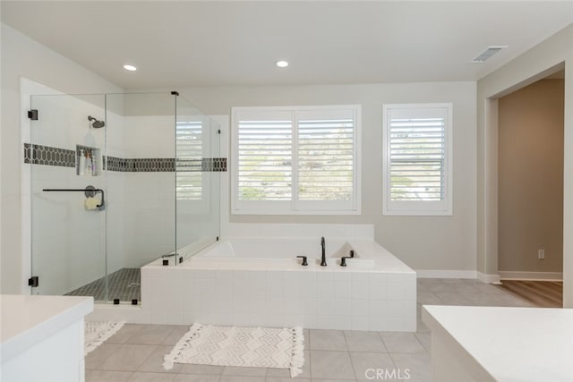 bathroom featuring plus walk in shower, vanity, tile patterned floors, and a wealth of natural light