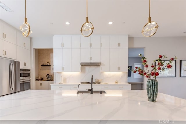 kitchen featuring appliances with stainless steel finishes, tasteful backsplash, white cabinetry, and pendant lighting