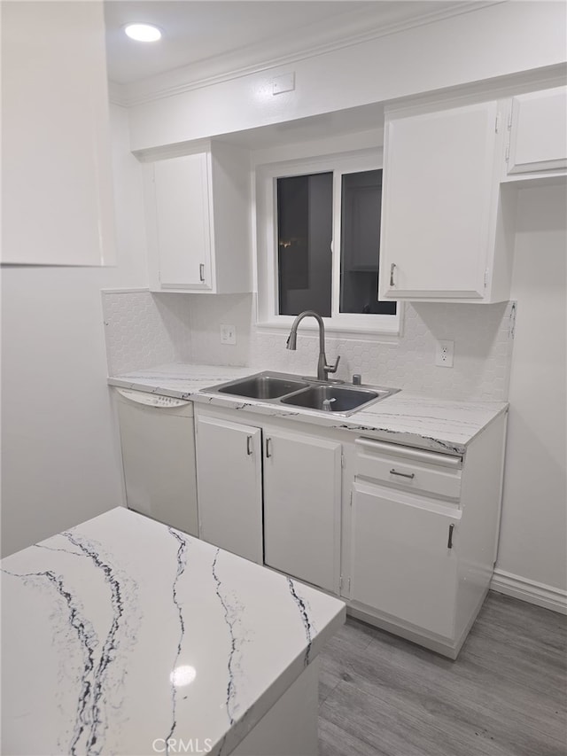 kitchen featuring light hardwood / wood-style floors, sink, white dishwasher, light stone countertops, and white cabinets