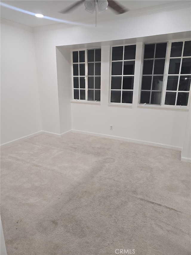 carpeted empty room with ceiling fan and crown molding