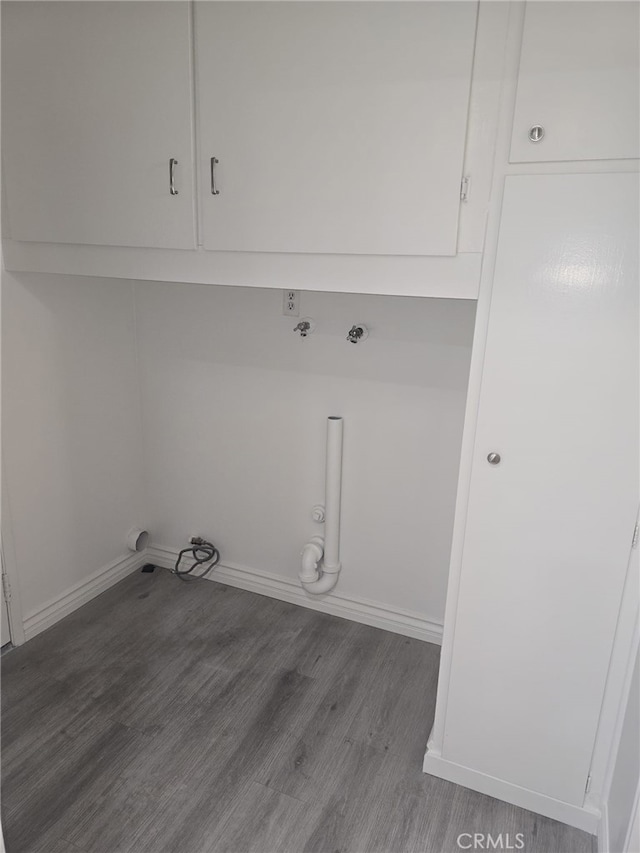 clothes washing area featuring cabinets, wood-type flooring, and hookup for a gas dryer