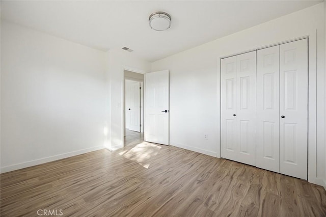 unfurnished bedroom featuring light wood-type flooring and a closet