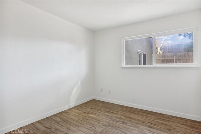 empty room with hardwood / wood-style flooring