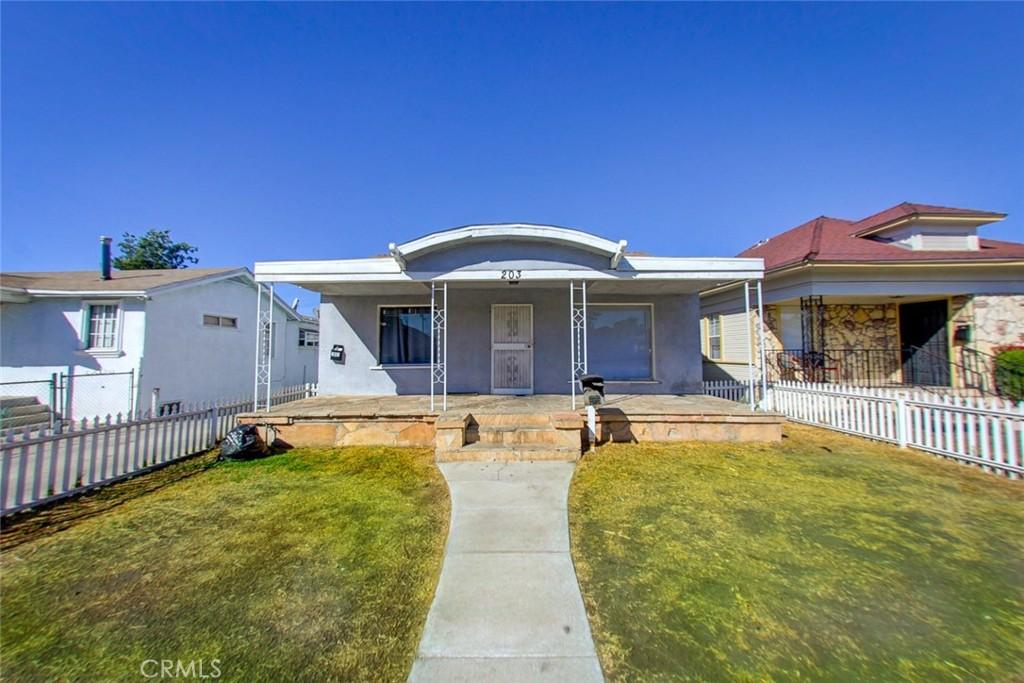 203 E 56th St, Los Angeles, CA 90011 - view of front facade with covered porch, a fenced backyard, and stucco siding