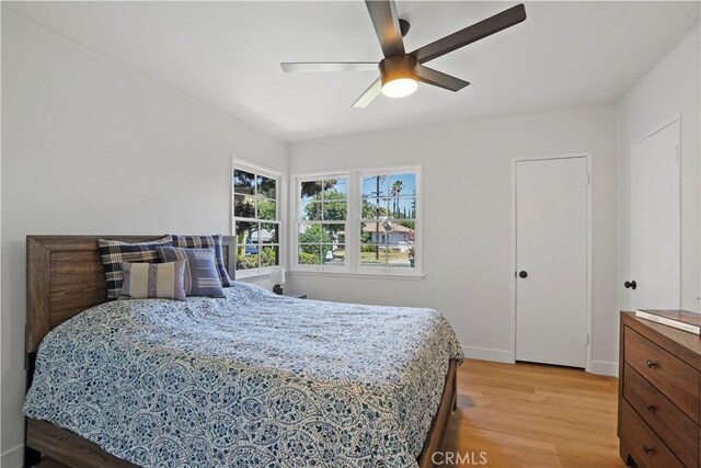 bedroom with ceiling fan and light wood-type flooring