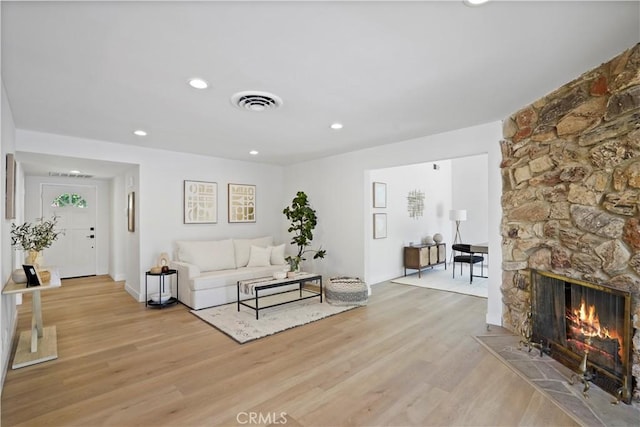 living room with a fireplace and light hardwood / wood-style flooring