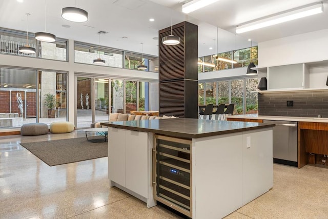 kitchen featuring dishwasher, a center island, decorative light fixtures, white cabinetry, and beverage cooler