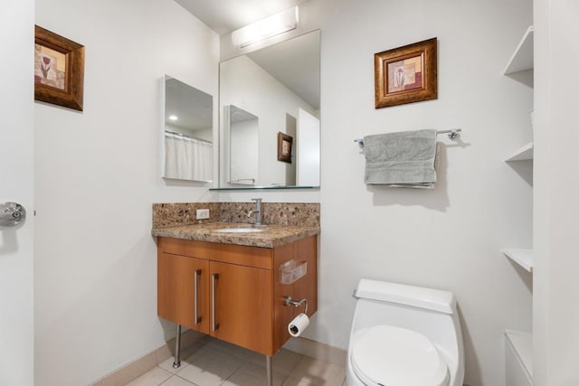 bathroom with tile patterned flooring, vanity, and toilet