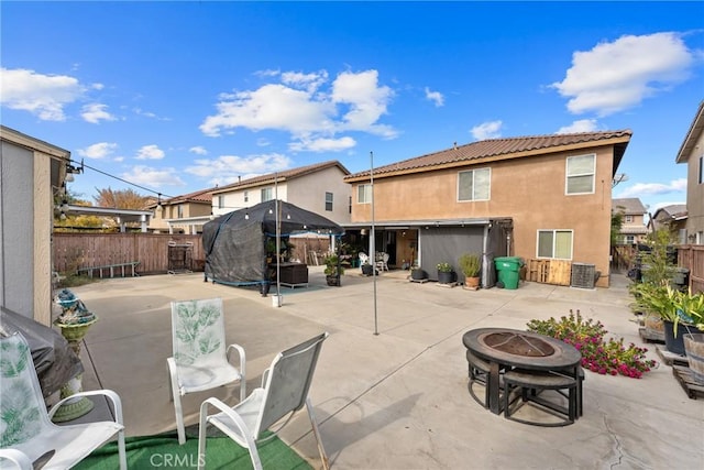 rear view of property with an outdoor fire pit and a patio