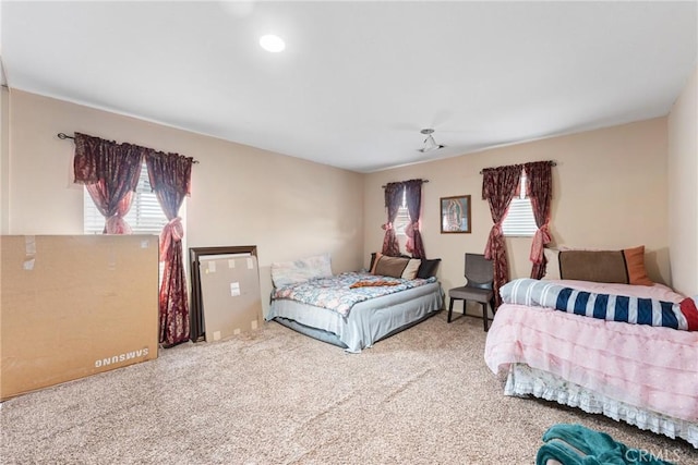 carpeted bedroom featuring multiple windows