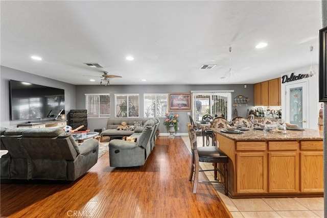 living room featuring light wood-type flooring and ceiling fan