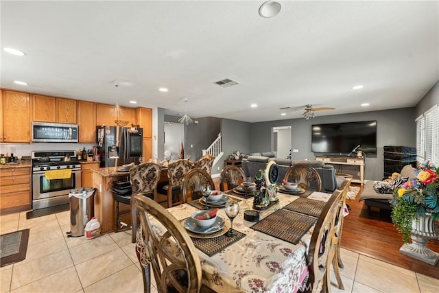 dining space with light tile patterned floors and ceiling fan